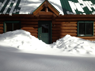 log cabin in the winter piles of snow
